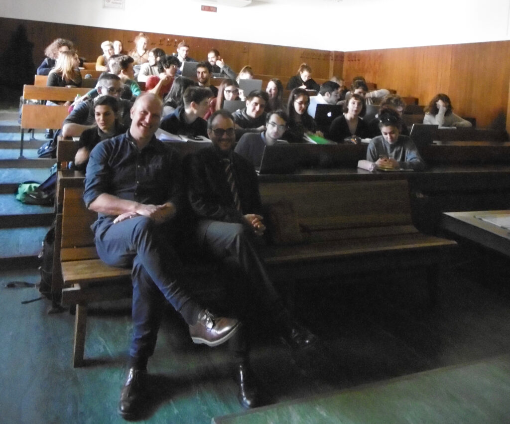 Mehrere Personen sitzen in einem kleinen Hörsaal einer Universität.