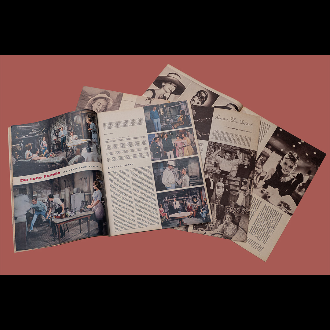 Drei aufgeschlagene Ausgaben der Zeitschrift "Film und Frau" liegen auf einer roten Unterlage